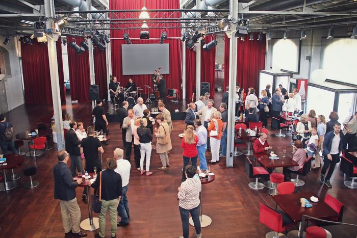 Gente hablando y tomando algo en un evento de la Fundación
              Goethe