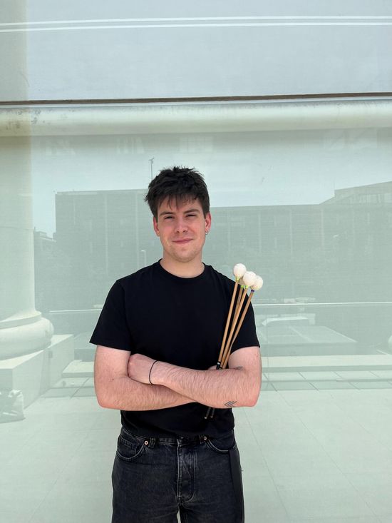 Íñigo Dúcar mit den Trommelstöcken in der Hand, lächelt in die Kamera.
