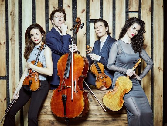 Vier Mitglieder des Parallel Quartetts posieren mit ihren Streichinstrumenten vor einer hölzernen Kulisse: Alfredo Ancillo und Laura V. Hidalgo an den Violinen, Fátima Poblete an der Bratsche und Stamen Nikolov am Cello.